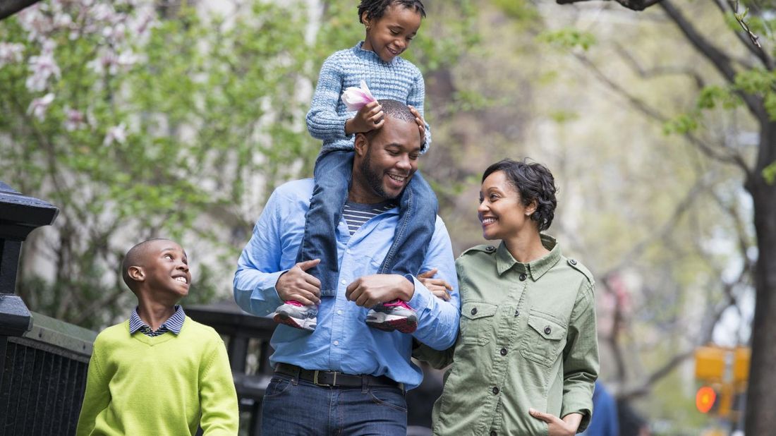 family including children with life insurance walking in city park