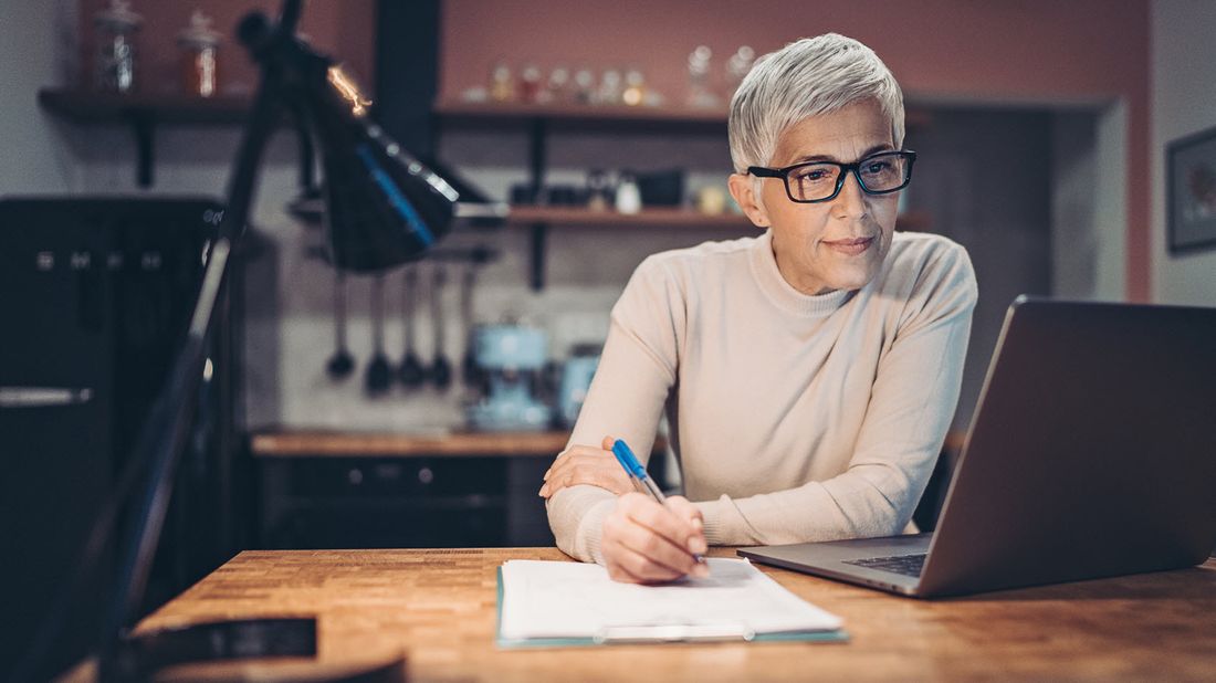Mature woman checks for mutual fund capital gains distributions in her portfolio