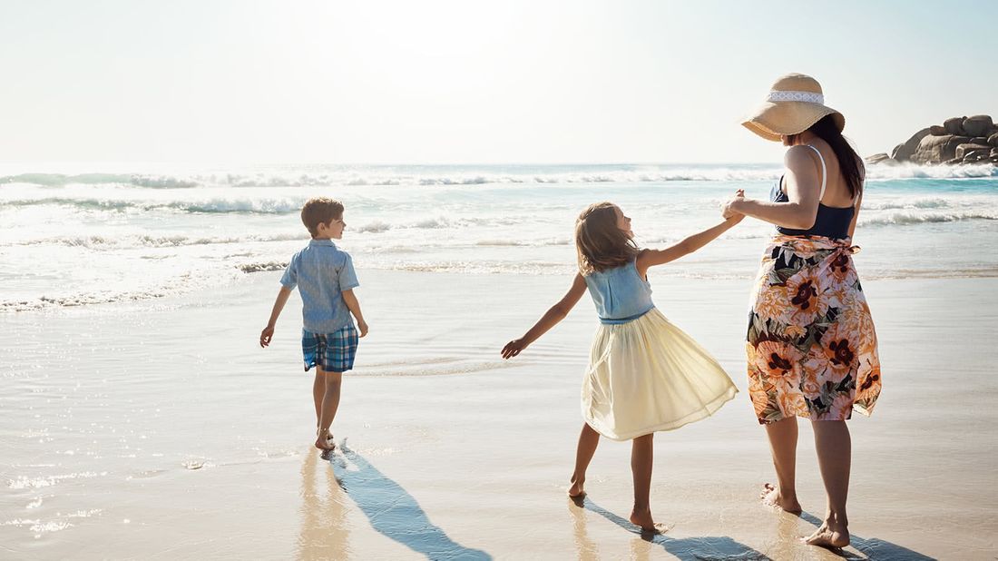 Mother with her two children on the beach