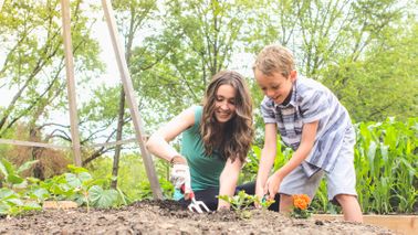 mother and son planting a garden