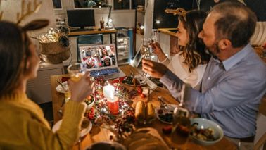 Family sharing holiday experience with friends on video call 