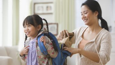 mom helping daughter get ready for school