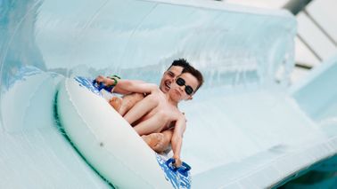 Father and son going down water slide.