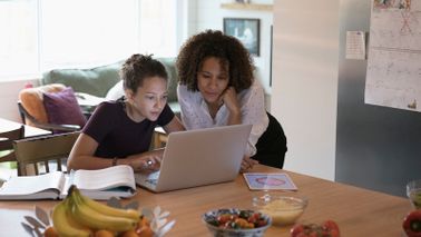 mom and daughter working on FAFSA in kitchen
