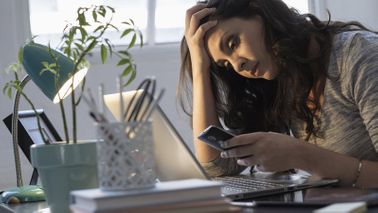 Woman looking at her phone trying to research her debt collection rights.