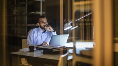 Man at desk reading Northwestern Mutual Market Commentary