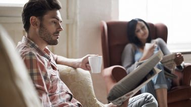 Husband and wife reading conflicting market news.
