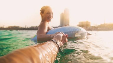 Couple in a pool after finding great travel deals