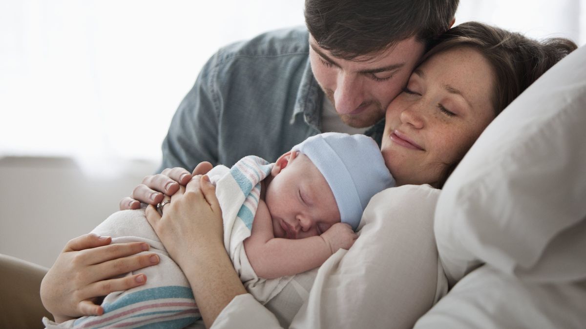 Mother and father holding new baby.